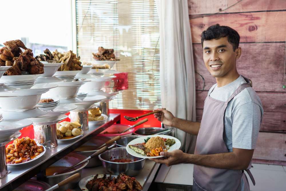 young man preparing food for guest at restaurant